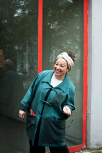 Load image into Gallery viewer, Lady stands by window laughing, wearing a overshirt jacket with three ties at centre front as fastenings

