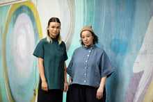 Load image into Gallery viewer, Two ladies wear short sleeved shirts with stand collar and button fronts down the left side, off-centre
