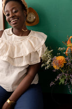 Load image into Gallery viewer, Lady sits laughing, wears a sleeveless top with two layers of pleated ruffles across shoulders
