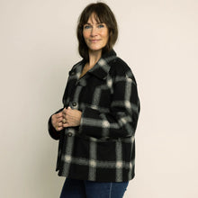 Load image into Gallery viewer, Side view of model wearing a checkered fabric coat, with three large buttons along centre front button stand
