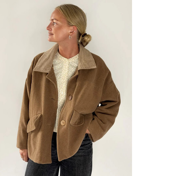 Model wears a short coat with contrasting fabric collar