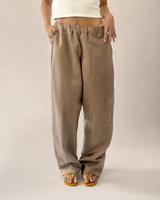 Load image into Gallery viewer, Front view of model wearing elasticated waist trousers with curved legs
