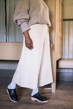Load image into Gallery viewer, Lady mid walk wearing wide legged cropped trousers with button detail at side seam at hem
