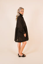 Load image into Gallery viewer, Side view of lady wearing Ashling long sleeved dress, with frill collar, frill cuffs, gathered waistline, knee-length skirt
