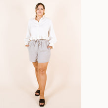 Load image into Gallery viewer, Lady stands with hands in pockets. Wear a cropped Ashling blouse with frill cuffs and hem
