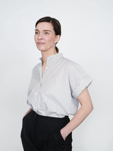 Load image into Gallery viewer, Lady poses with hands in pockets wearing the Cap Sleeve shirt tucked in
