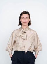 Load image into Gallery viewer, Front view of Tie Bow Blouse worn tucked into trousers
