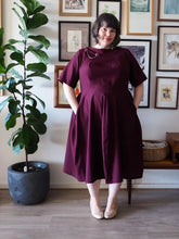 Load image into Gallery viewer, Lady wears the Tulip Dress with both hands in inseam sidepockets 
