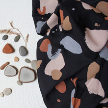 Load image into Gallery viewer, Viscose fabric sits slightly crumpled amongst pebbles
