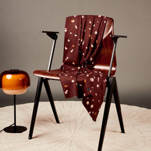 Load image into Gallery viewer, Fizzy Rust EcoVero Viscose Twill fabric draped over a wooden chair next to a floor lamp
