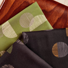 Load image into Gallery viewer, Three folded fabric pieces lay on chair in three different colourways
