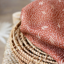 Load image into Gallery viewer, Viscose Crepe Fabric with dots and leaf motifs sits on top of a wicker piece
