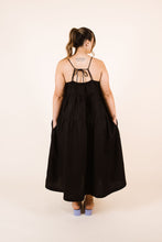 Load image into Gallery viewer, Back view of lady wearing Celestia tier dress with hands in pockets, and drawstring fastening at back neckline
