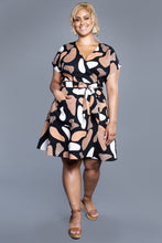 Load image into Gallery viewer, Lady wears a mini skirt length Elodie Wrap Dress with hand in pocket
