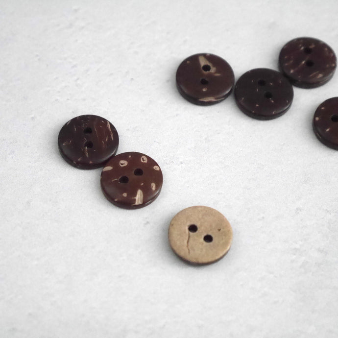 A display of 2-hole coconut buttons with the various natural pattern of two colours