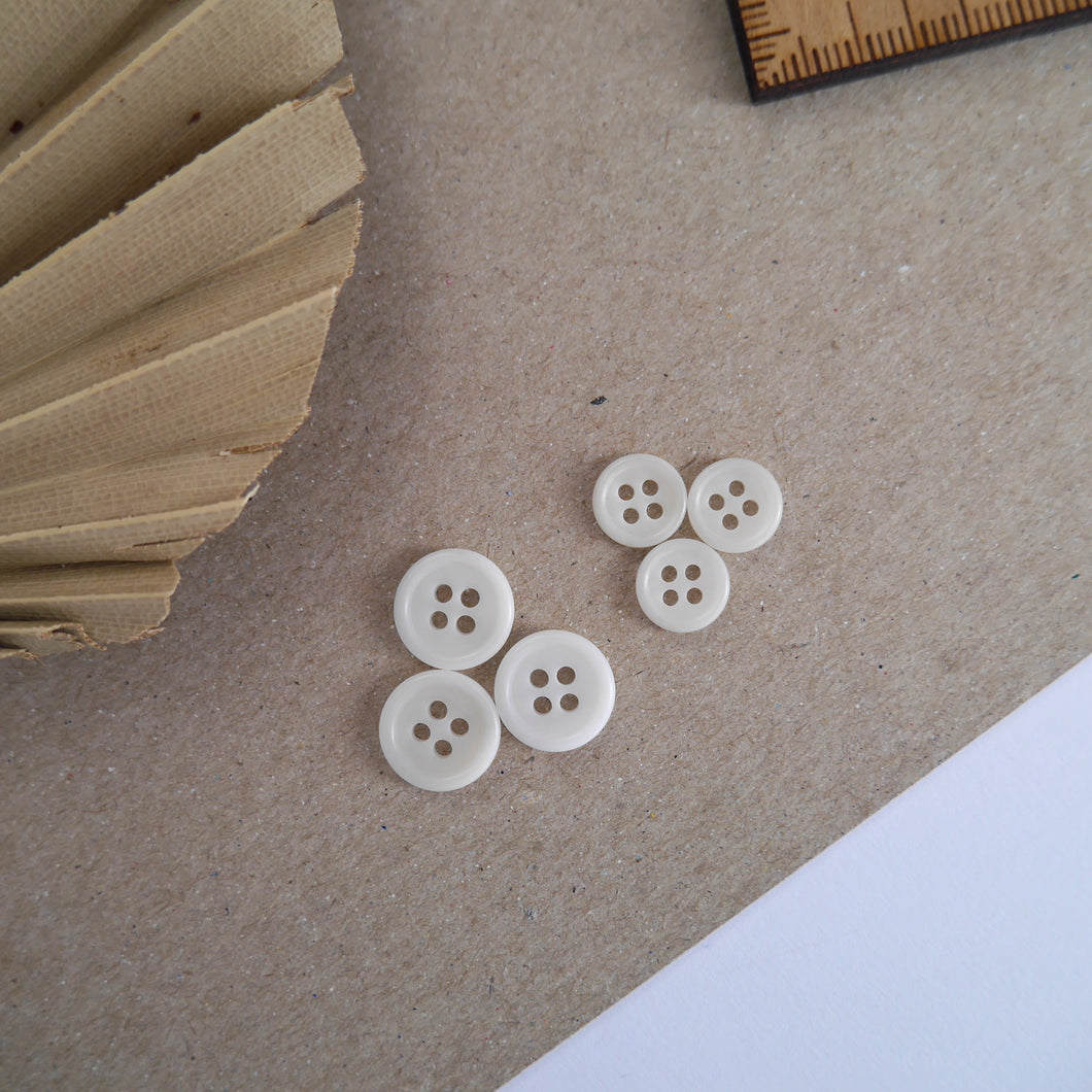 Three 11m buttons next to three 8mm 4-hole Corozo buttons
