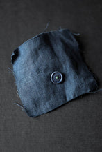 Load image into Gallery viewer, One dusty blue colour hard cotton button sewn onto a matching blue linen swatch.
