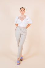 Load image into Gallery viewer, Lady wears a cross- over cropped top with puff sleeves
