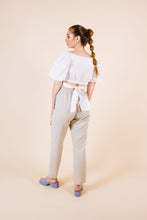 Load image into Gallery viewer, Back view of crop top with puff sleeves and waist ties tied at back
