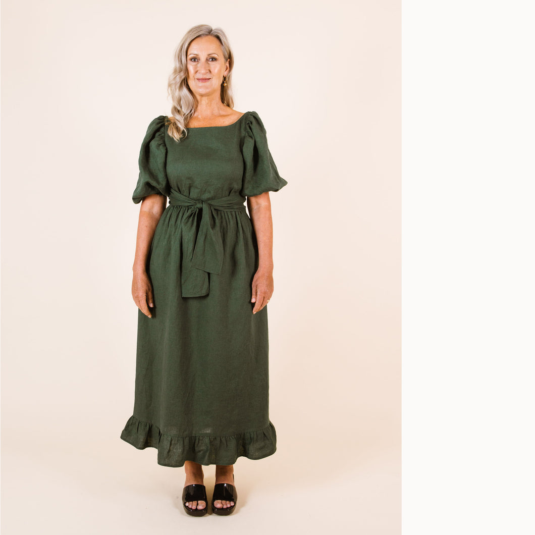 Lady wears Estella Dress with puff sleeves and frill ankle hem, tie at waist