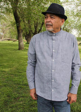 Load image into Gallery viewer, Man wears long-sleeve Jensen shirt with stand collar and one chest pocket in a light blue chambray fabric.
