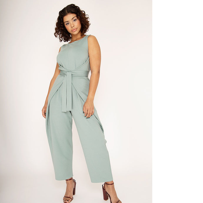 Lady wears mint green jumpsuit tied at front waist.