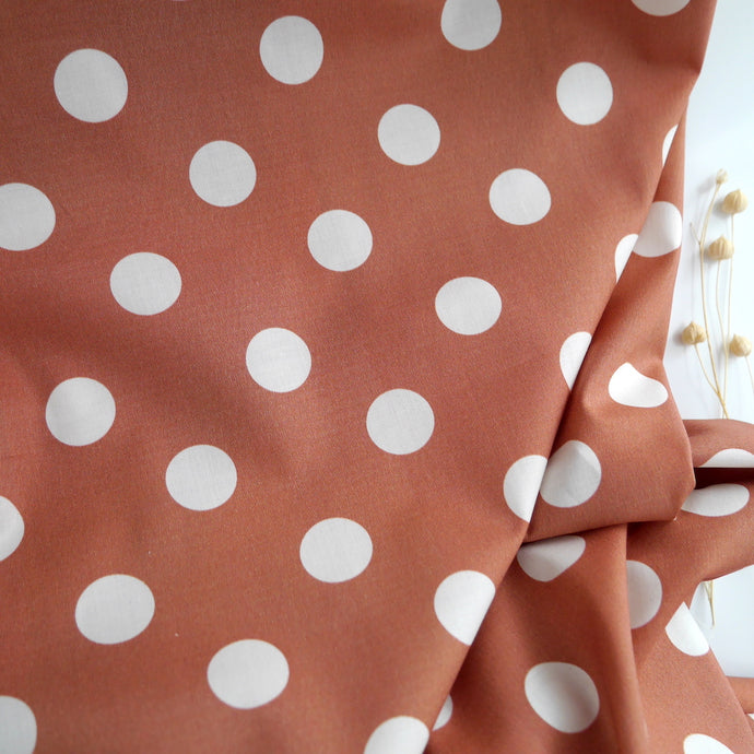 Spot design fabric gently folded on top of a plain surface