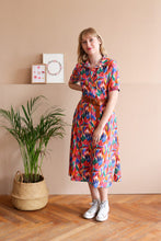 Load image into Gallery viewer, Full length view of lady standing wearing a midi length shirt dress made with Wonderland EcoVero Viscose fabric.
