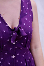 Load image into Gallery viewer, Close up of lady wearing a V-neck with tie bow detail, sleeveless dress made with Coeur A Prendre Viscose print fabric
