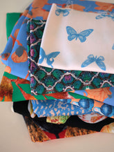 Load image into Gallery viewer, Pile of folded Madame Iris fabrics with various pattern prints
