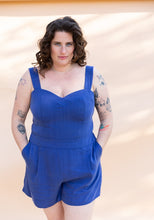 Load image into Gallery viewer, Lady wears a bustier and shorts jumpsuits with hands in pockets of shorts
