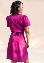 Load image into Gallery viewer, Back view of lady wearing a short-sleeved blouse, skirt with knotted tie at waist
