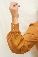 Load image into Gallery viewer, Close up of sleeve and cuff with 2 buttons. Sleeve made up of 2 different colour panels
