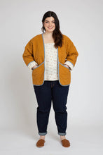 Load image into Gallery viewer, Lady stands wearing a quilted Hovea Jacket with hands in front slanted pockets
