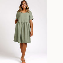 Load image into Gallery viewer, Lady wears a loose fit tee dress with gathered waist, hand in pocket of side inseam skirt
