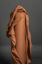 Load image into Gallery viewer, Bolt of Organic Cotton Voile fabric stood upright, with end of fabric draped onto itself
