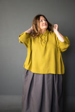 Load image into Gallery viewer, Lady stands wearing Shepherd Skirt with a bright coloured top
