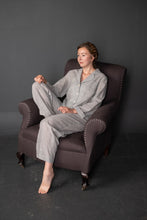 Load image into Gallery viewer, Lady sits on armchair wearing a matching long-sleeved and long trouser pyjama set
