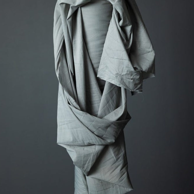 Top end of fabric roll stood up with Organic Cotton Voile fabric draped across itself