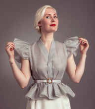Load image into Gallery viewer, Lady wears striped blouse with frilly peplum from waist, holding puffy sleeves from armhole.
