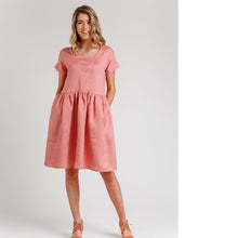 Load image into Gallery viewer, Lady stands with hands in pockets in a V-neck insert bodice with gathered waist knee length dress
