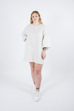 Load image into Gallery viewer, Lady stands wearing straight cut thigh length dress with puffy bell sleeves
