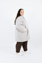 Load image into Gallery viewer, Side view of lady wearing Nova coat with hands in pockets
