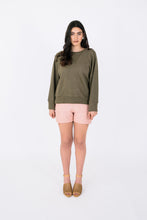Load image into Gallery viewer, Lady wears variation three of the Pinnacle Top, a long sleeved sweatshirt with neck band and cuffs
