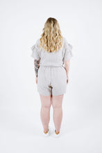 Load image into Gallery viewer, Back view of lady wearing Solar Tee with ruffles on sleeves
