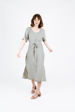 Load image into Gallery viewer, Front view of lady turning wearing Tide dress to show side splits at skirt, a round neckline and waist tie
