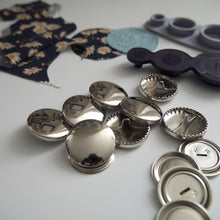 Load image into Gallery viewer, 29mm metal cover button blanks displayed next to cover tool and circular pieces of fabric
