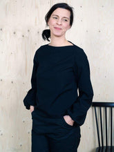 Load image into Gallery viewer, Lady wears a wide neckline black top, with long sleeves that puff at the wrist. 
