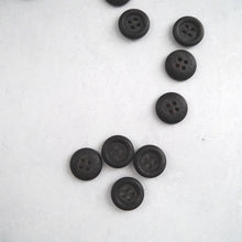 Load image into Gallery viewer, Top view of scattered Recycled Paper buttons, show 4-hole with rounded ridge on outer edge on one side. The words &#39;Recycled Paper&#39; raised on the other side, slightly domed.
