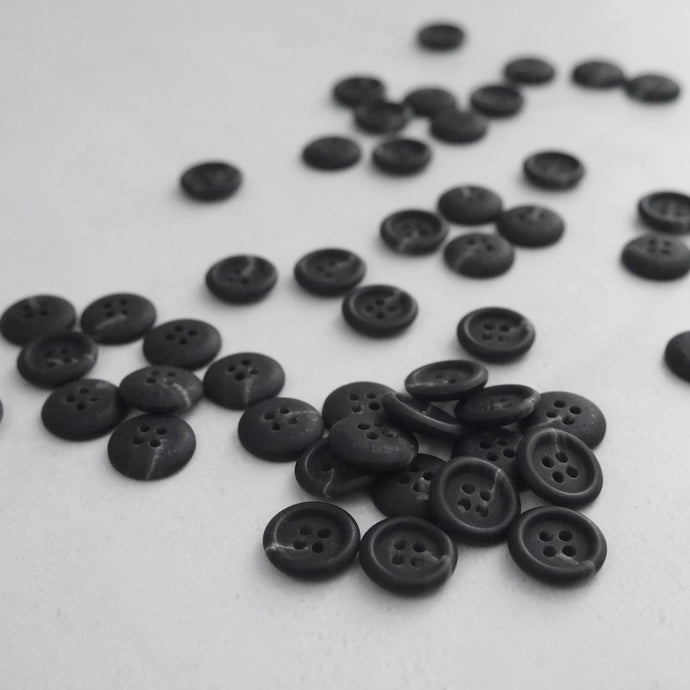 Buttons with four holes, scattered across worktop